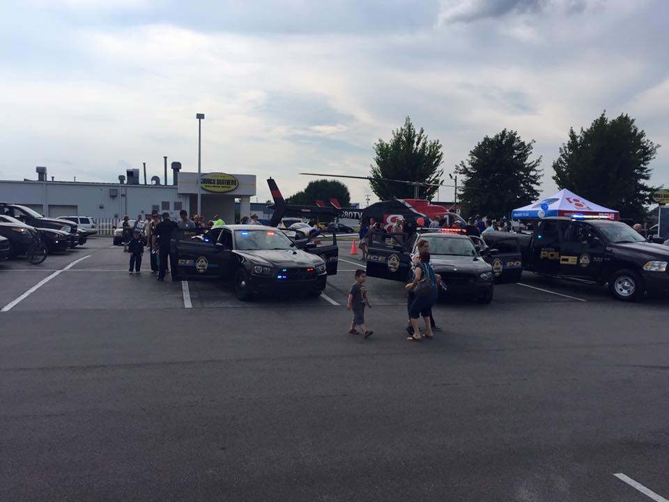 Police Vehicles and Helicpoter in Parking Lot Open for People to Look In